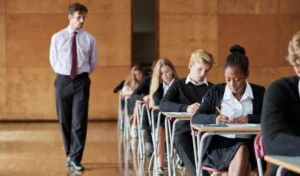 A teacher invigilating learners writing an exam