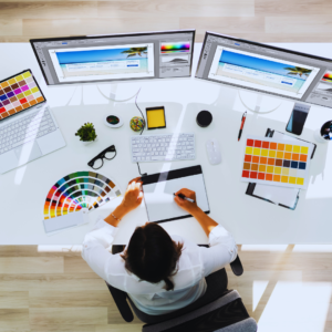 A graphic designer sitting on his desk with laptops on